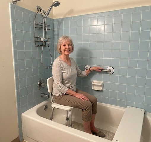 Locataire senior lisant la loi sur l'adaptation du logement pour faire installer une douche sécurisée